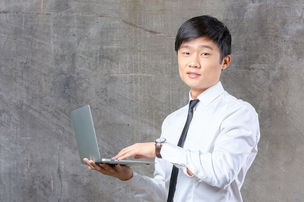 Jovem, sorrindo, asiático, homem negócios, segurando, laptop