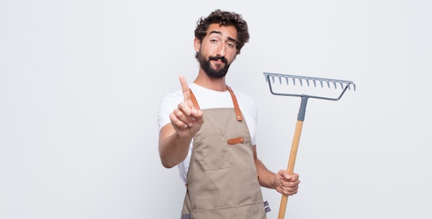 Jovem sorrindo com orgulho e confiança fazendo a pose número um triunfantemente, sentindo-se um líder