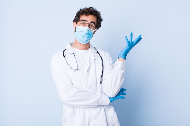 Jovem sorrindo com orgulho e confiança, sentindo-se feliz e satisfeito e mostrando um conceito no espaço da cópia. conceito de coronavírus