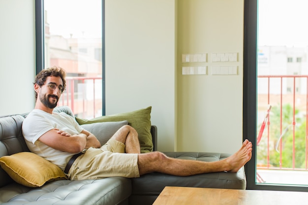 Jovem sorrindo com os braços cruzados e uma expressão feliz, confiante e satisfeita