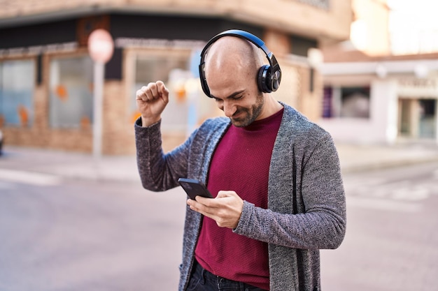 Jovem sorrindo confiante ouvindo música na rua