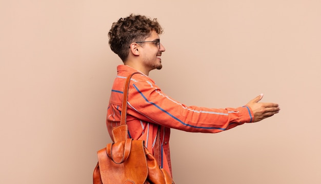 Jovem sorrindo, cumprimentando você e dando um aperto de mão isolado