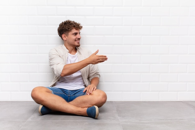 Jovem sorrindo, cumprimentando você e oferecendo um aperto de mão para fechar um negócio de sucesso, o conceito de cooperação