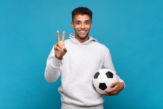 Jovem sorrindo e parecendo amigável, mostrando o número dois ou o segundo com a mão para a frente, em contagem regressiva. conceito de futebol