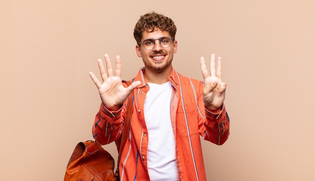 Jovem sorrindo e parecendo amigável, mostrando o número oito ou oitavo com a mão para a frente, em contagem regressiva. conceito de estudante