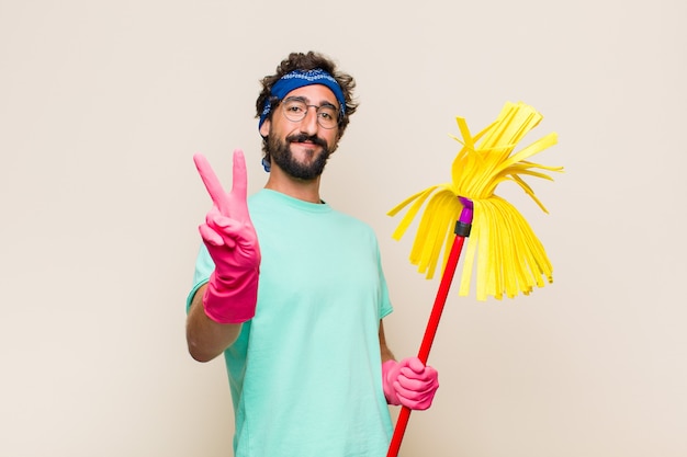 Jovem sorrindo e parecendo feliz, despreocupado e positivo, gesticulando vitória ou paz com uma mão