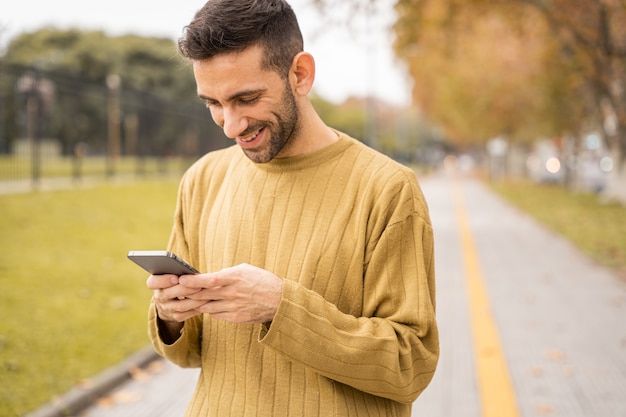 Jovem sorrindo e usando o celular