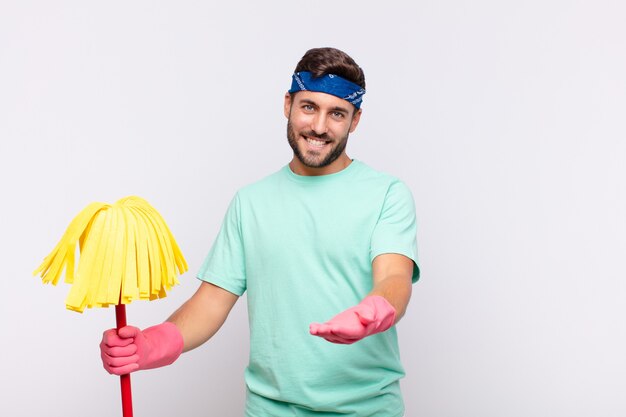 Jovem sorrindo feliz com um olhar amigável, confiante e positivo, oferecendo e mostrando um objeto ou conceito