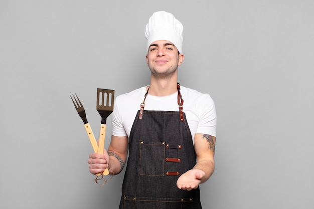 Jovem sorrindo feliz com um olhar amigável, confiante e positivo, oferecendo e mostrando um objeto ou conceito