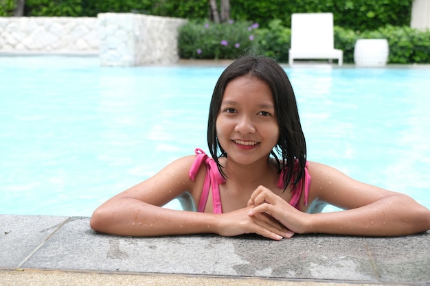 Jovem sorrindo para a piscina