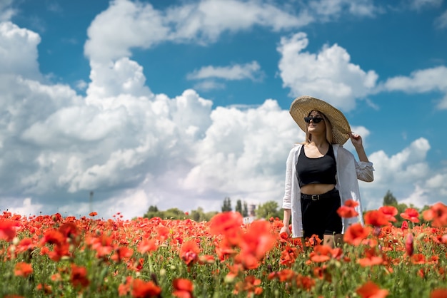 Jovem sozinha com papoula no campo, dia de verão