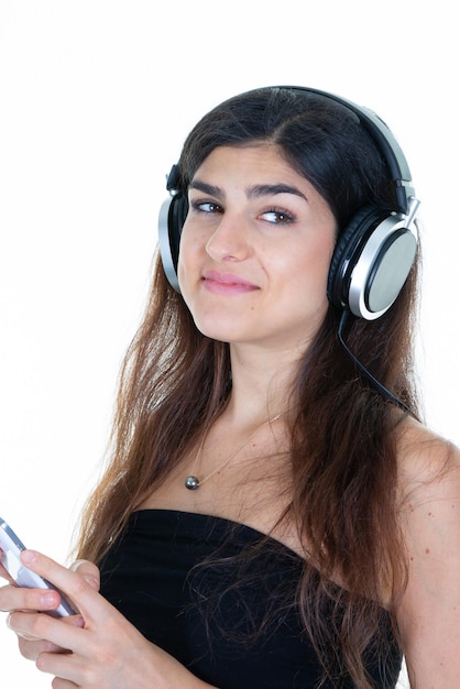 Jovem sul-americana ouvindo música com celular e fones de ouvido no fundo branco