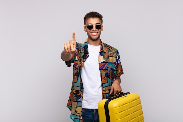 Jovem sul-americano sorrindo e parecendo amigável, mostrando o número um ou o primeiro com a mão para a frente, em contagem regressiva