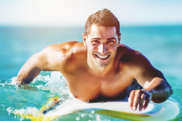 Jovem surfista boiando na água azul