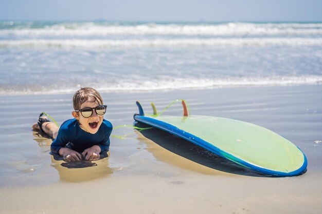 Jovem surfista feliz menino na praia com prancha de surf