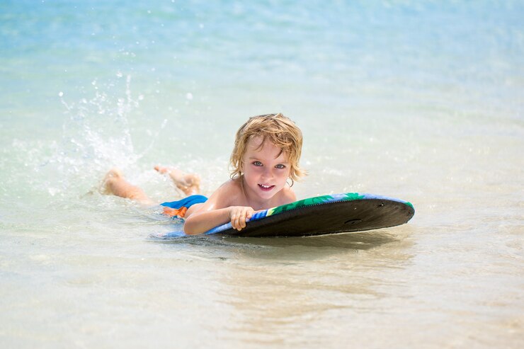 Foto jovem surfista, menino feliz no oceano na prancha de surf