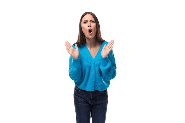 Jovem surpresa encantadora mulher morena vestida com blusa azul com vneck em fundo branco com