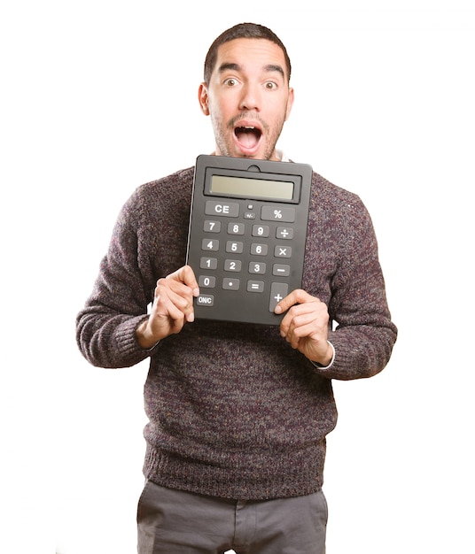 Jovem surpreso segurando uma calculadora