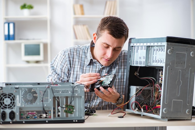 Foto jovem técnico consertando computador na oficina