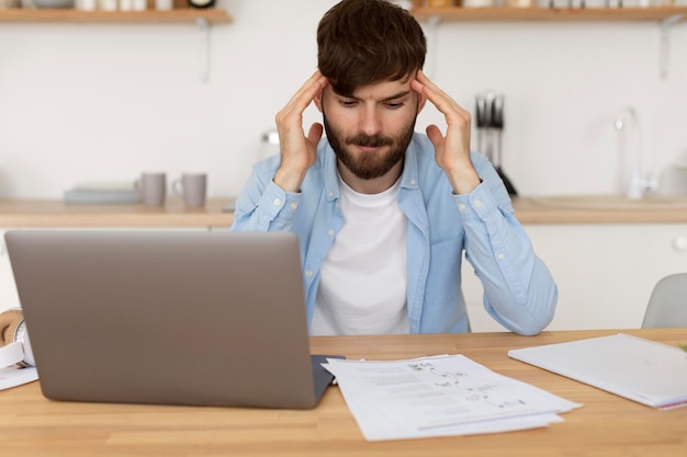 Jovem tendo uma dor de cabeça enquanto trabalha