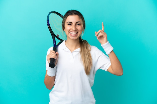 Foto jovem tenista isolada em um fundo azul apontando uma ótima ideia