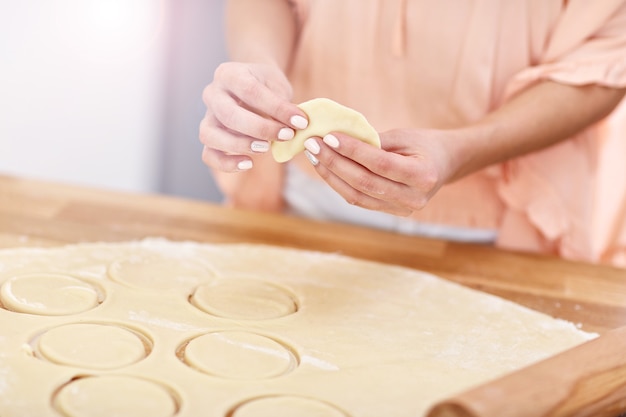 jovem tentando fazer pierogi na cozinha