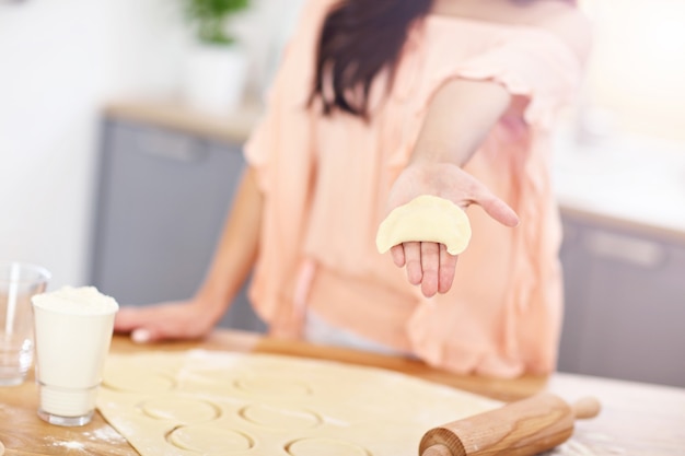 Jovem tentando fazer pierogi na cozinha