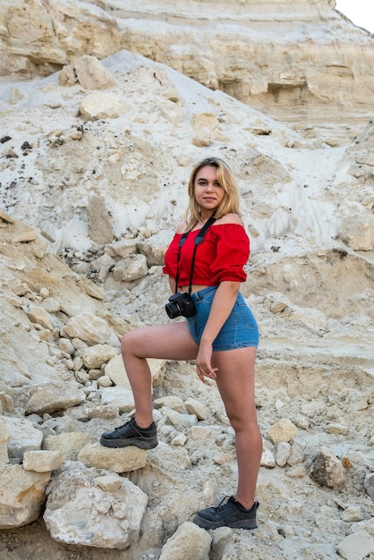 Jovem tirando fotos em um desfiladeiro de rochas de areia, explorando a natureza e fazendo sol