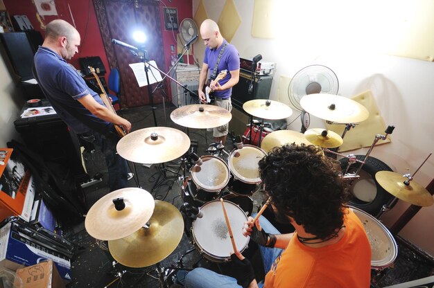 Foto jovem tocador de música e amigos da banda treinam na garagem de casa