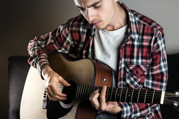 Jovem tocando acorde na guitarra