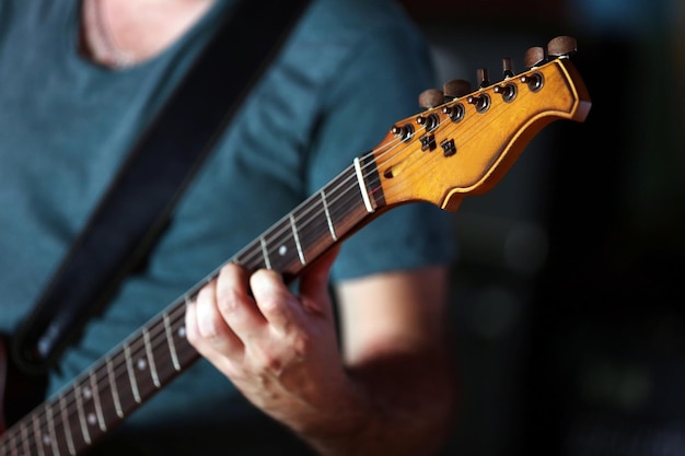 Jovem tocando guitarra elétrica de perto