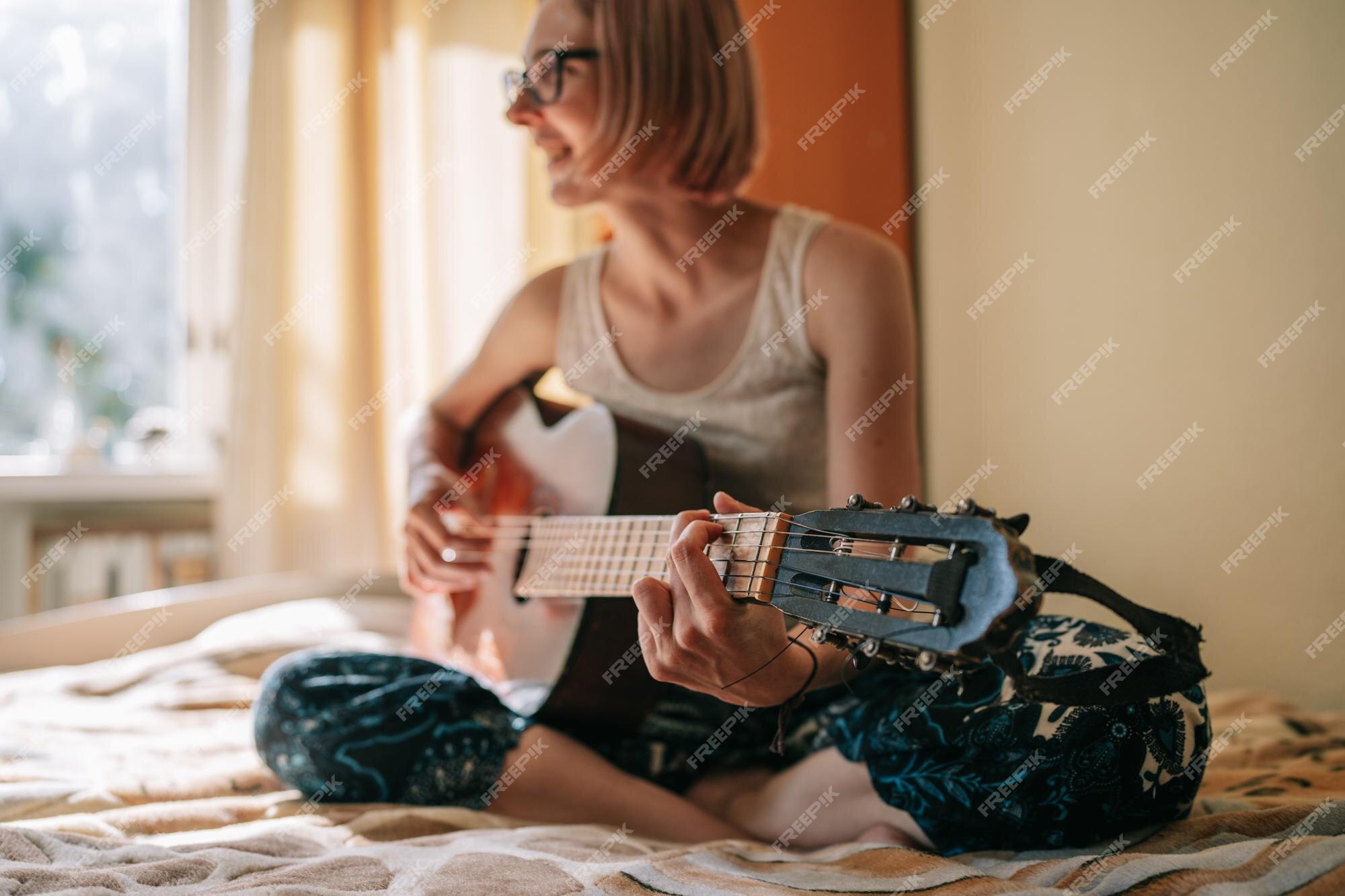 Fotos de Triste mulher jovem sentada com guitarra nas mãos