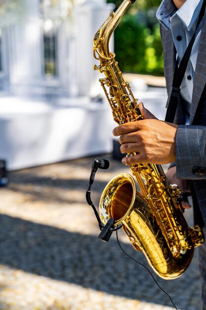 Jovem tocando saxofone no casamento Fundo desfocado Foco seletivo