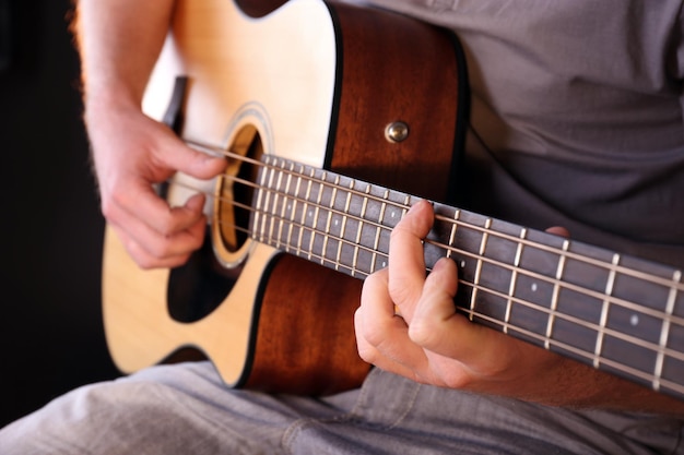 Jovem tocando violão de perto