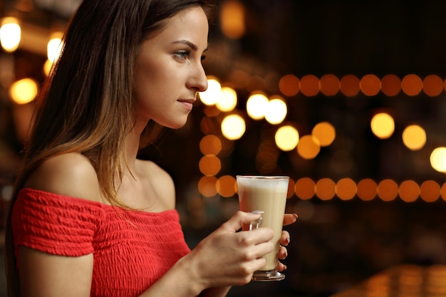 jovem tomando café em um café