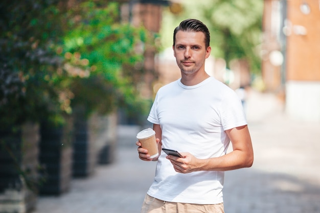 Jovem tomando café na cidade ao ar livre