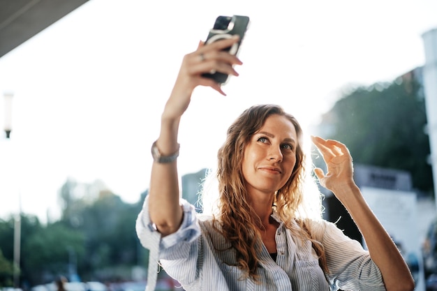 Jovem tomando selfie em smartphone na rua