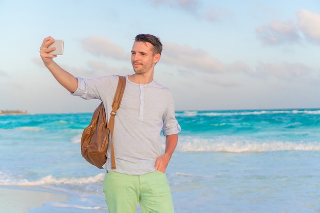 Jovem tomando selfie na praia