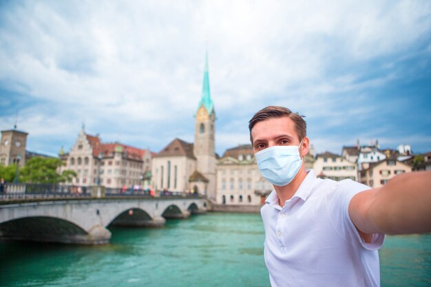 Jovem tomando selfie na velha cidade europeia tirar selfie. Usando uma máscara facial para prevenção de coronavírus