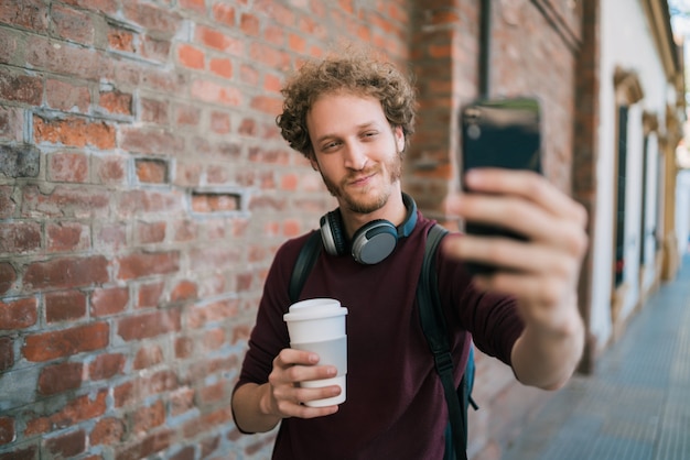 Jovem tomando selfies com telefone.