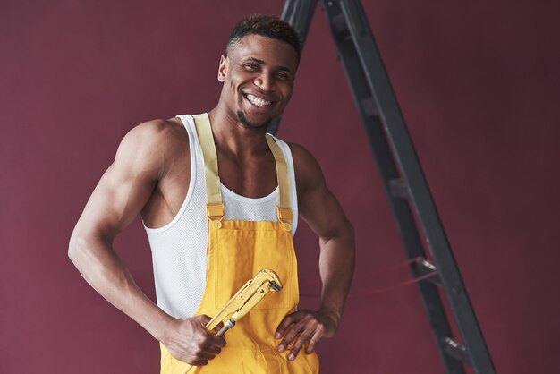 Jovem trabalhador afro-americano de uniforme amarelo tem um emprego