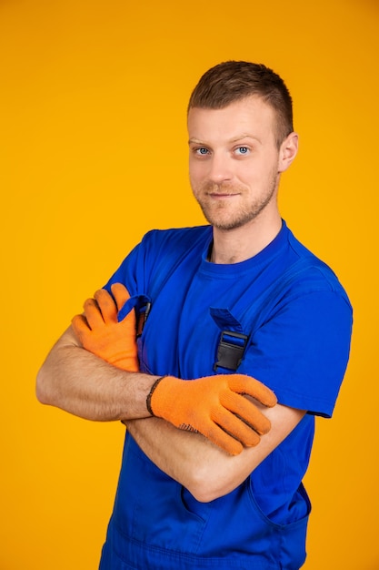 Jovem trabalhador masculino em luvas e macacões