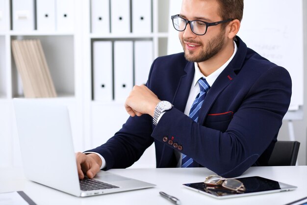 Jovem trabalhando com computador portátil, as mãos do homem no notebook, empresário no local de trabalho.