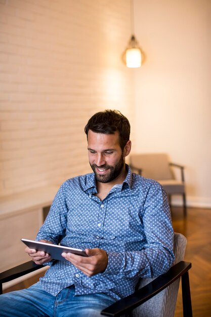 Jovem trabalhando em casa no tablet digital