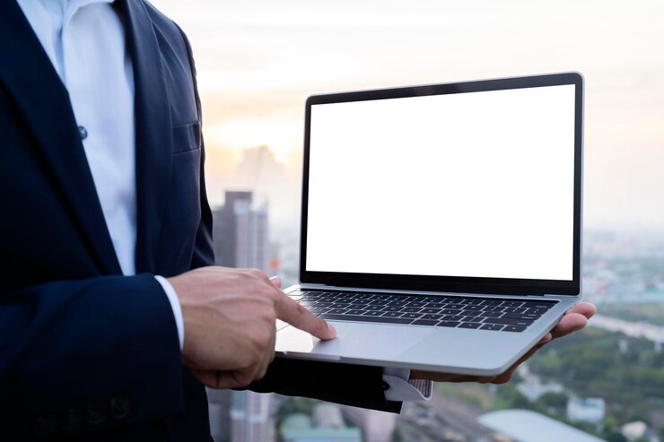 Jovem trabalhando em seu laptop com tela de espaço de cópia em branco para sua mensagem de texto de publicidade no escritório