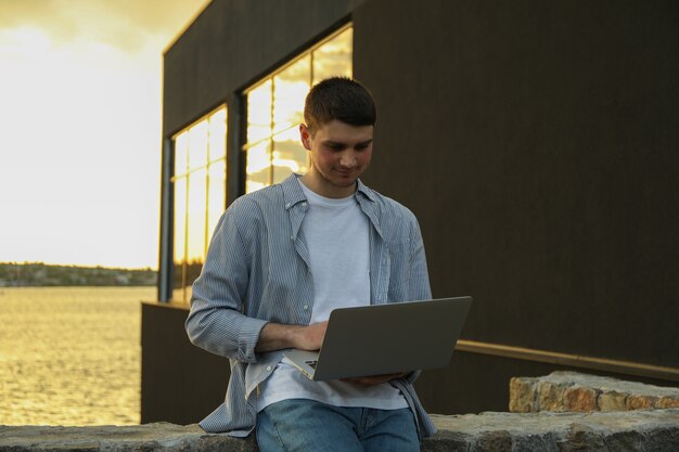 Jovem trabalhando em um laptop ao ar livre