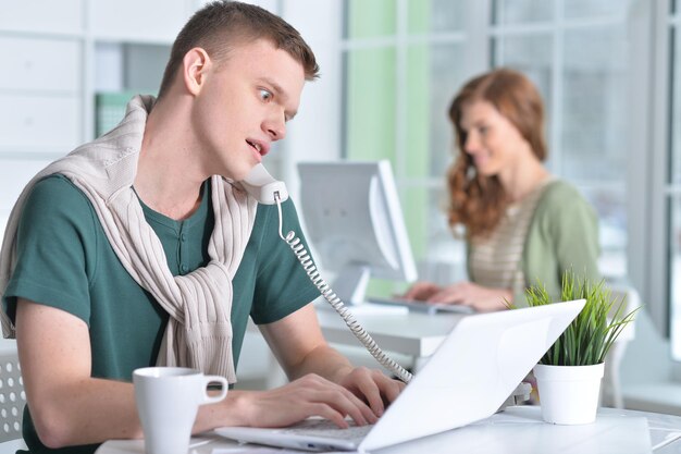 Jovem trabalhando no escritório com um laptop