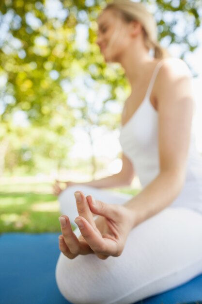 Jovem tranquila em um mapa de exercícios meditando