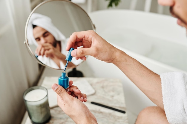 Jovem transgênero fazendo manicure