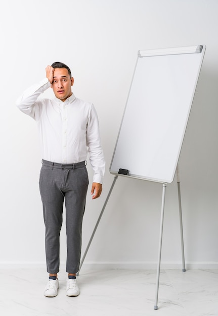 Jovem treinador latino com um quadro branco isolado em choque, ela se lembrou de um encontro importante.